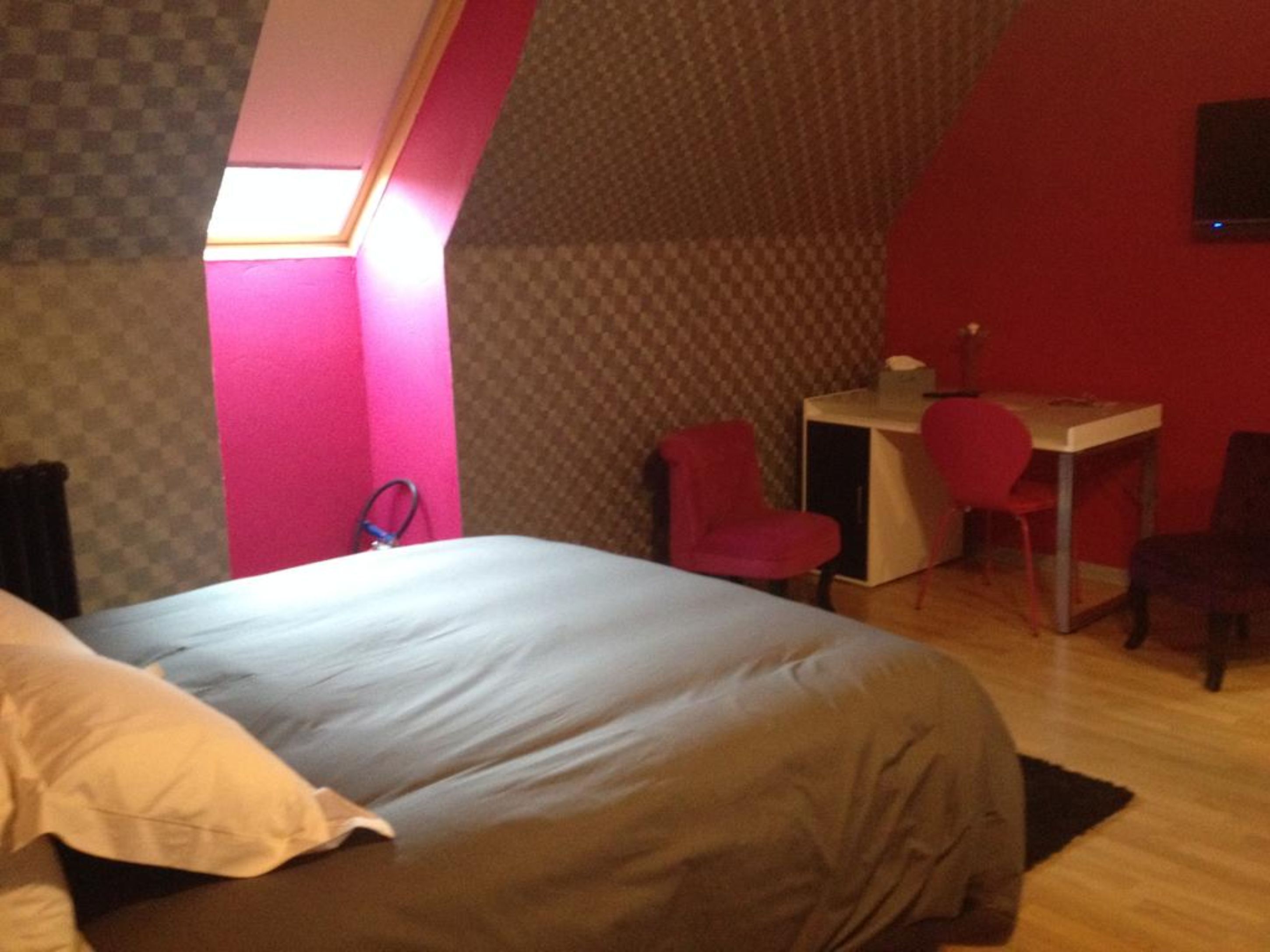 A bedroom with a bed, a desk, and two chairs.