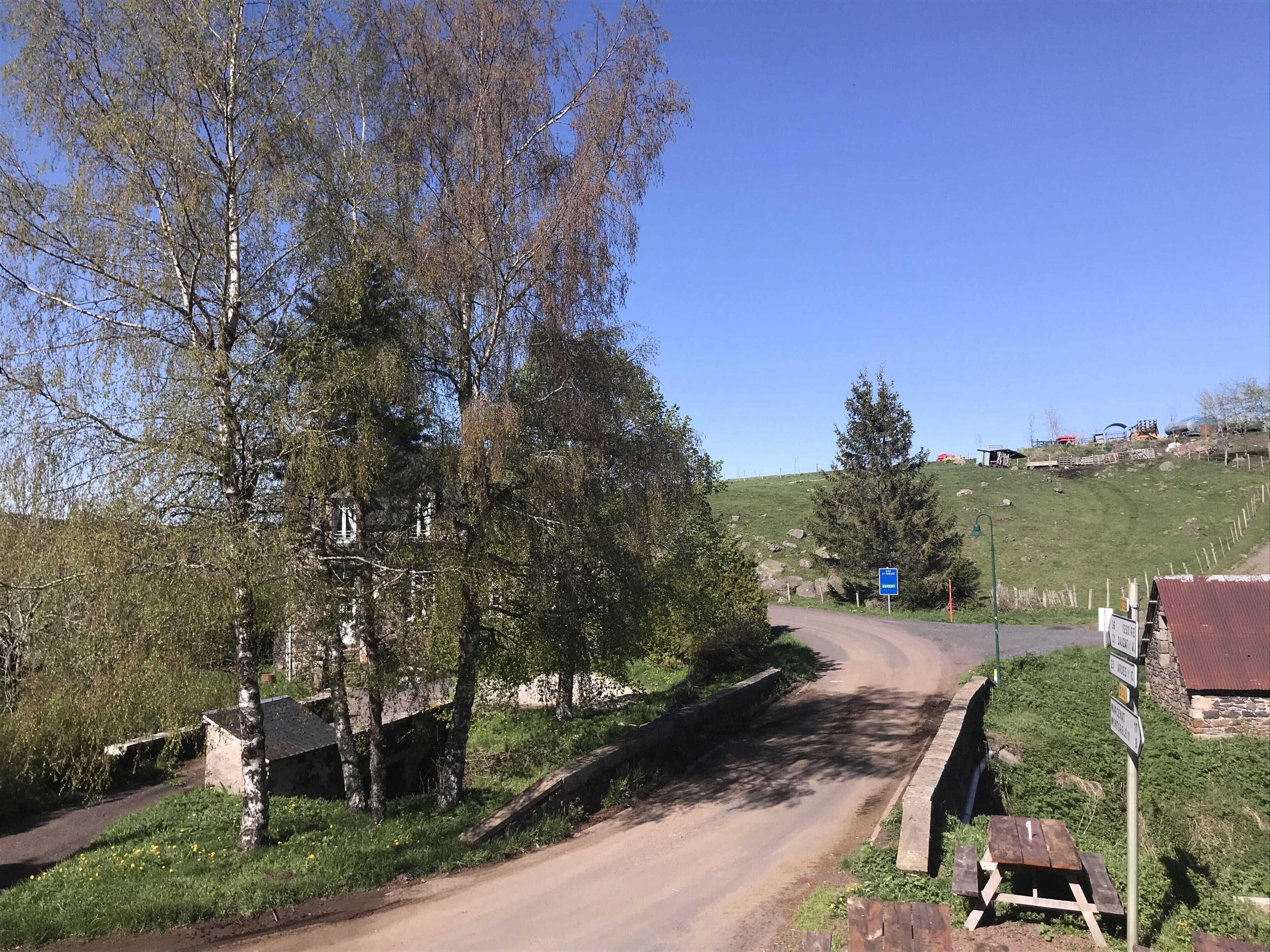 Un camino rural con una mesa de picnic y un cartel.