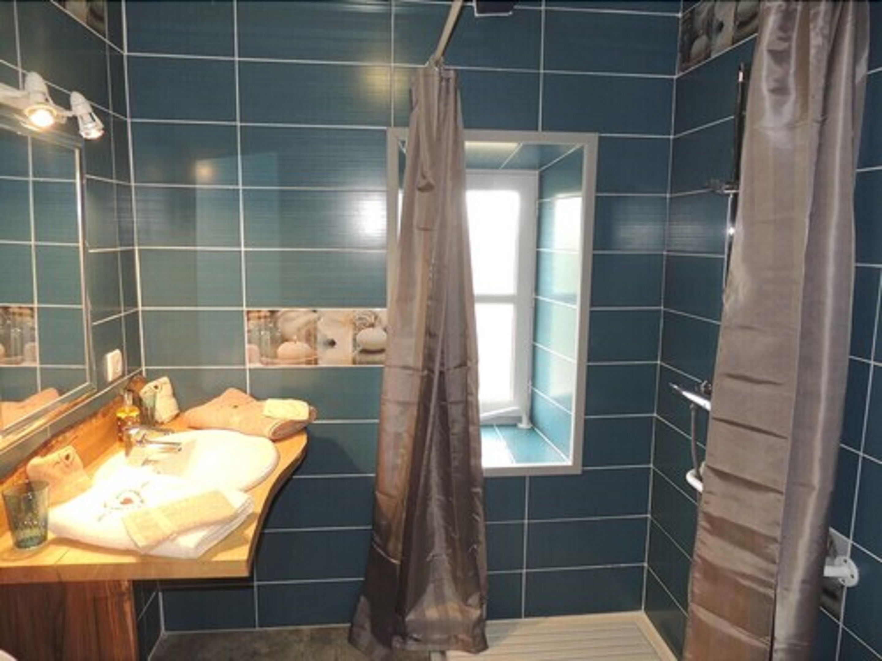 A bathroom with a sink, mirror, and a window with a view.