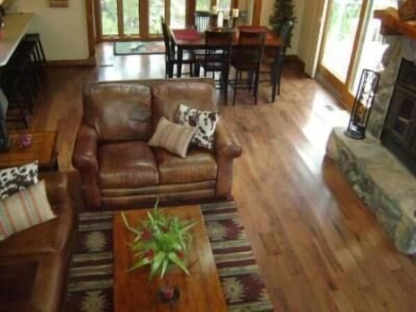 A living room with a leather sofa, a wooden coffee table, and a fireplace.