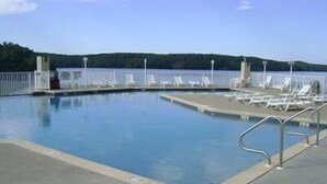 A swimming pool with lounge chairs and a view of a lake. - Towers 9106 4 Bedroom Condo by Your Lake vacation (Osage Beach)