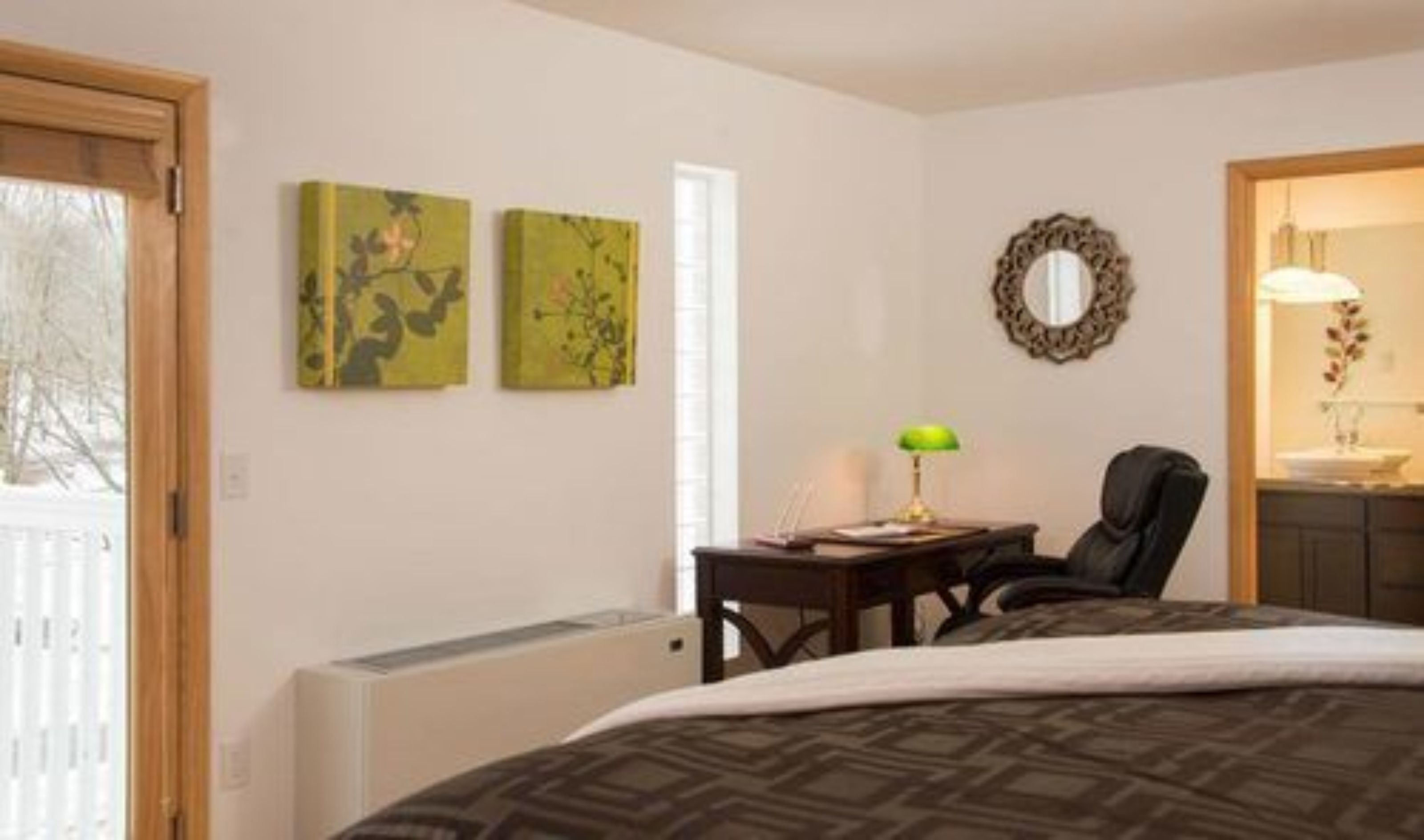 Ein Schlafzimmer mit einem Bett, einem Schreibtisch, einem Sessel und zwei an der Wand befestigten Bildern.