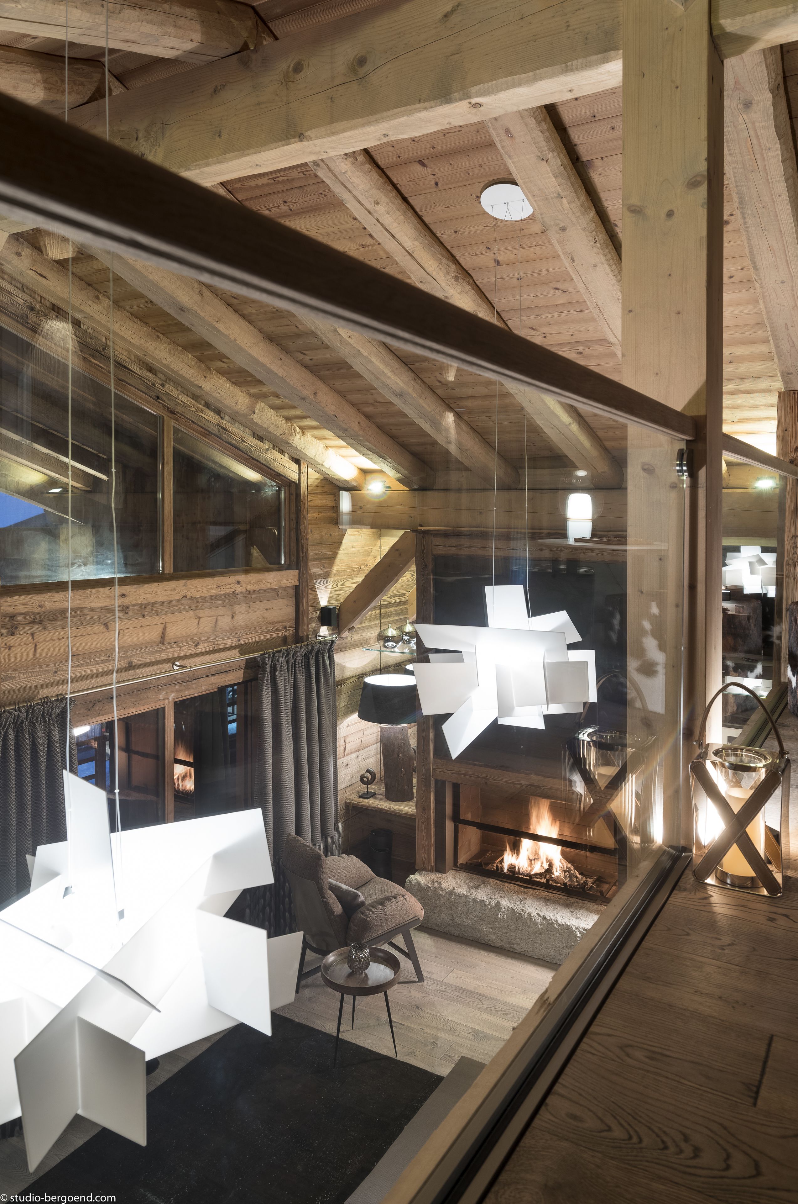 Een modern interieur met een houten plafond, een glazen wand en een open haard.