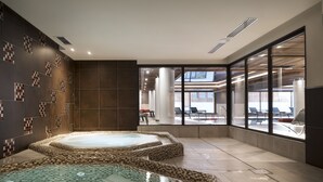 Een moderne spa met een jacuzzi en een afgesloten ontspanningsruimte.