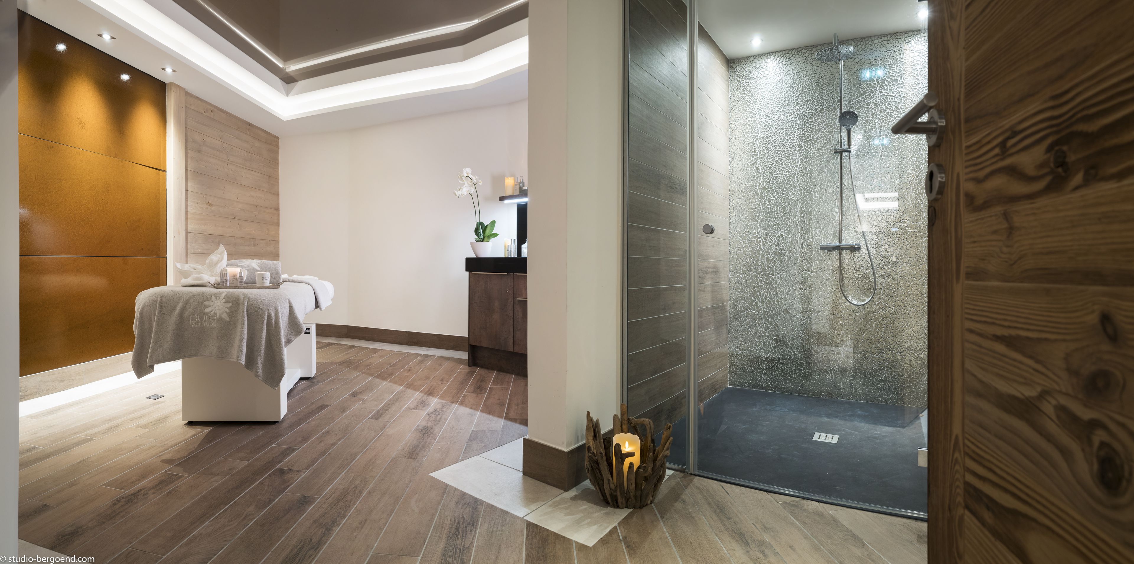 Un baño moderno con ducha, tocador y cama con toallas.