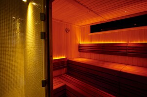 Una sauna con bancos de madera y pared de azulejos.