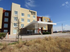 Un hotel Fairfield Inn & Suites de varios pisos con entrada cubierta y estacionamiento.