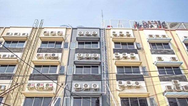 A multi-story building with multiple air conditioning units, a visible antenna, and a ladder on the left side. - RedDoorz @ Mangga Besar 2 (Jakarta)