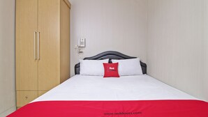 A hotel room with a bed, a wardrobe, and a telephone on the wall. - RedDoorz @ Mangga Besar 2 (Jakarta)