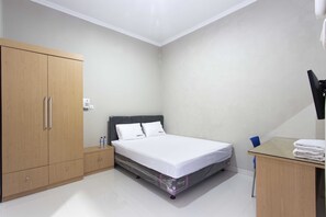 A bedroom with a bed, a wardrobe, a desk, and a chair. - RedDoorz @ Mangga Besar 2 (Jakarta)