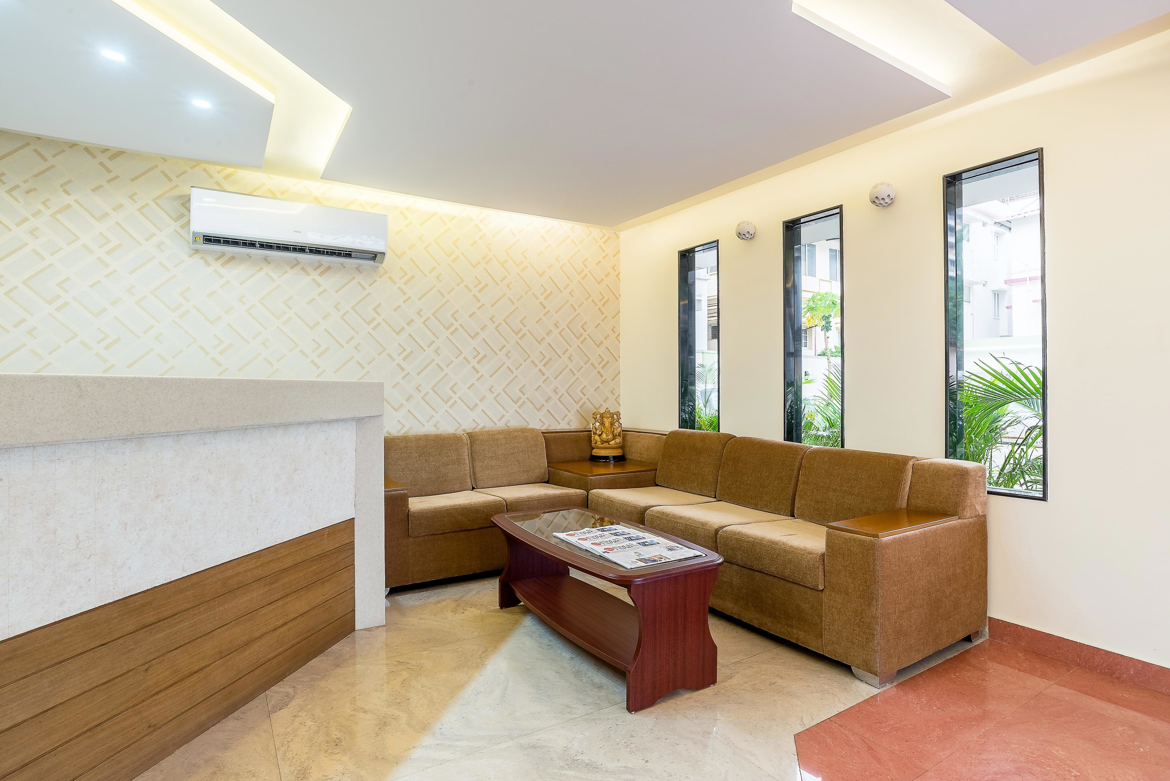 A modern living room with a sectional sofa, a wooden coffee table, and a built-in air conditioning unit.
