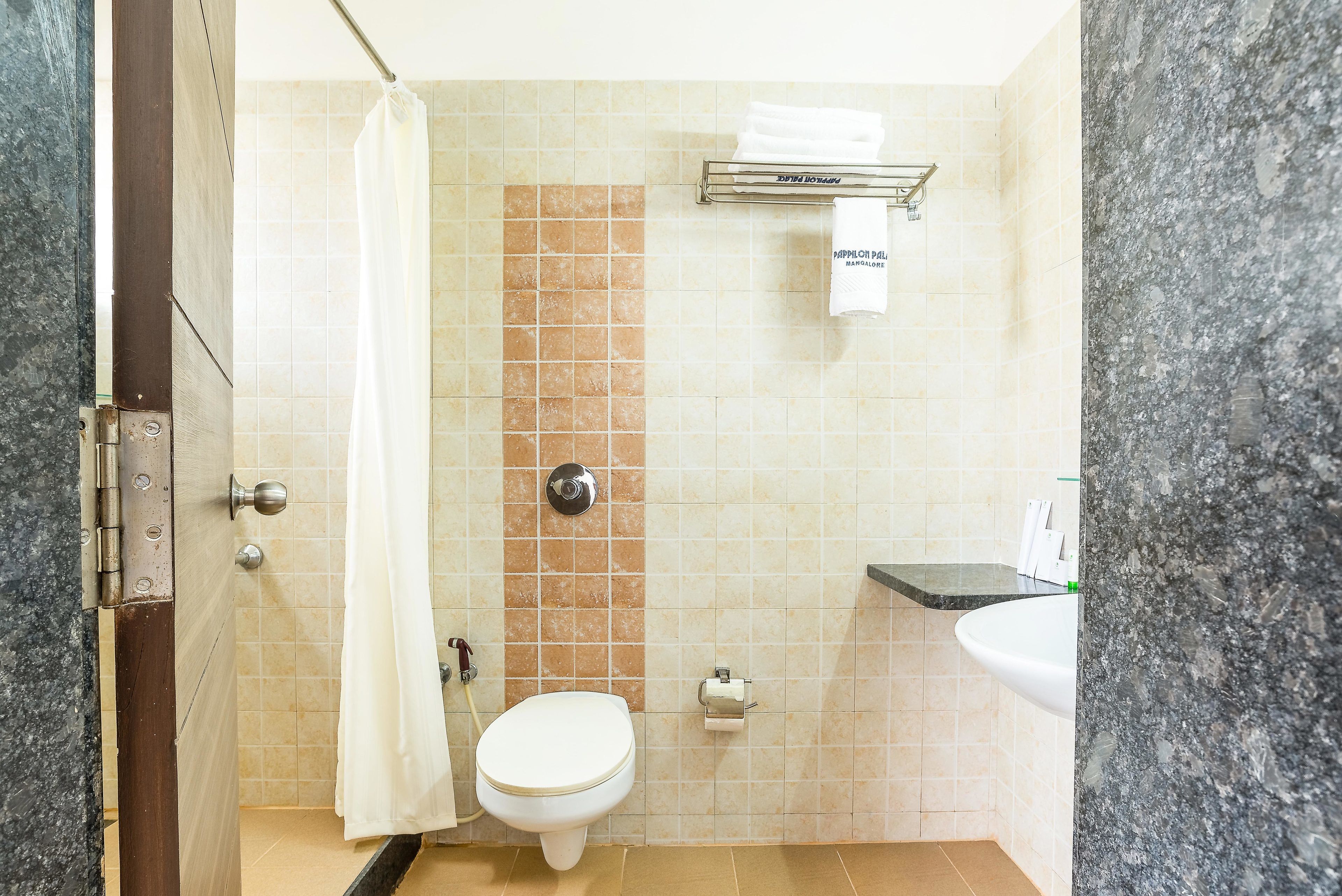 Een kleine badkamer met toilet, douche en wastafel.