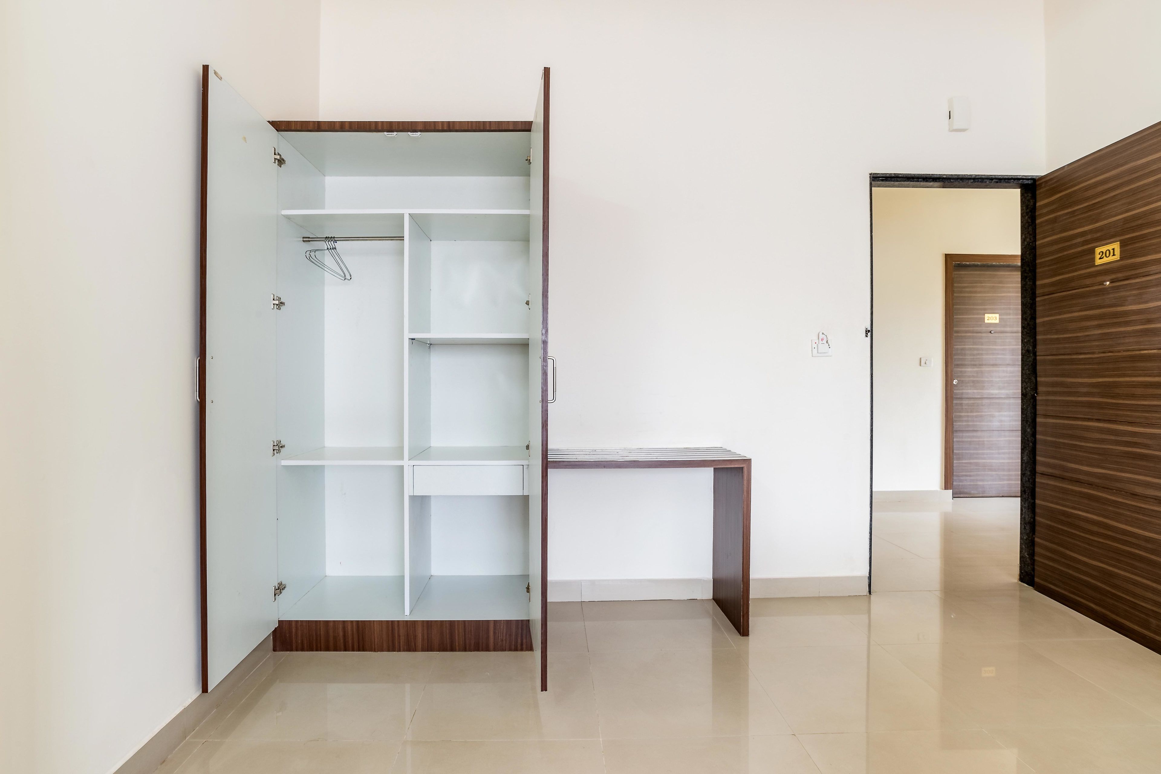 Una habitación con armario, escritorio y puerta.