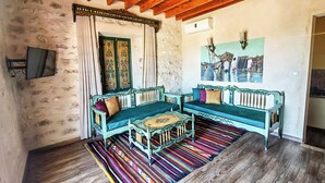 Suite familiar, cocina básica | Zona de estar | Televisión de pantalla plana de 32 pulgadas con canales por cable