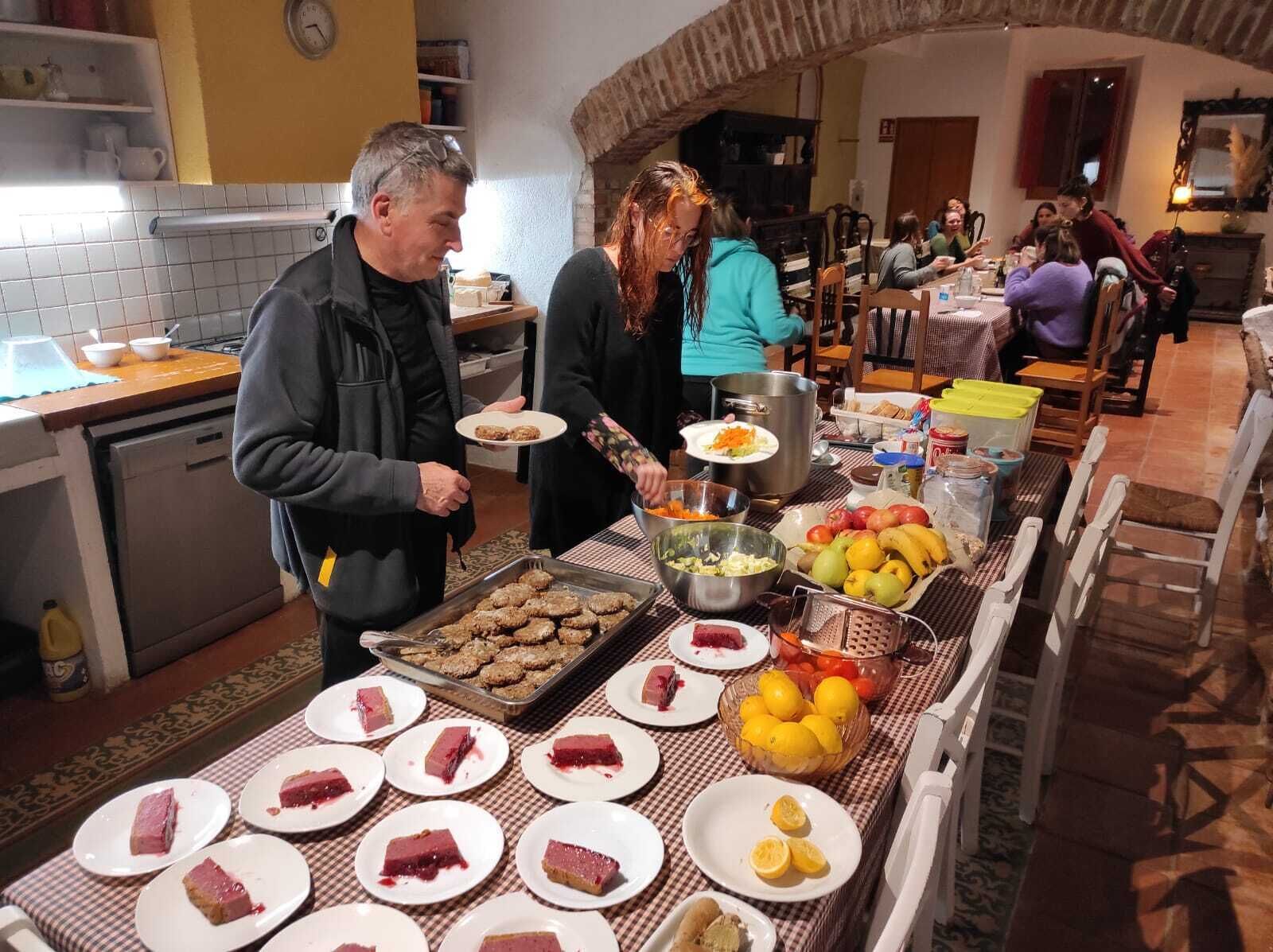 En buffet med forskellige retter, hvor en gruppe mennesker betjener sig selv.