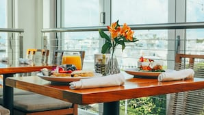 A breakfast setting with a table, chairs, a vase with flowers, and a city view. - Hilton Key West Resort & Marina (Key West)