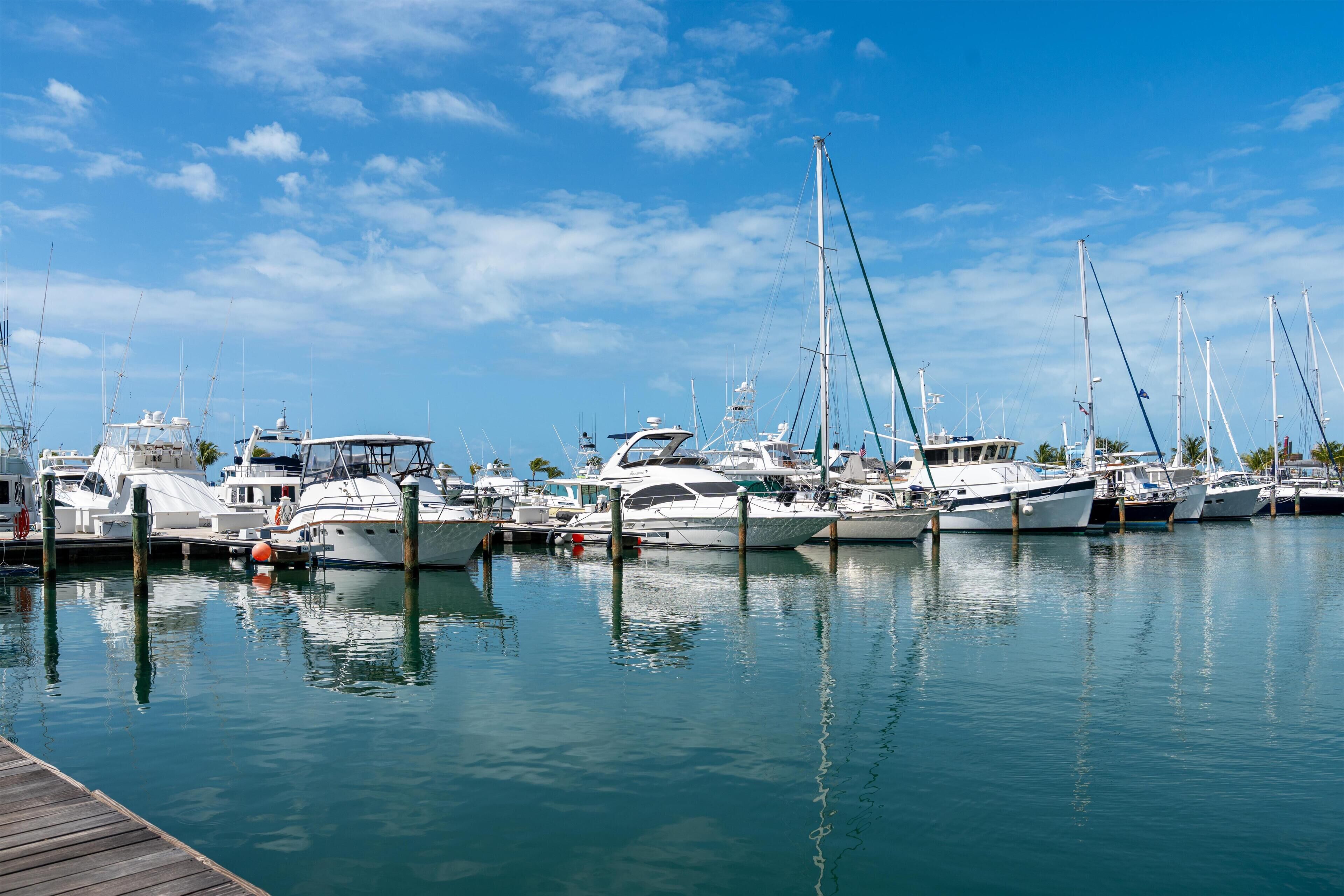 A marina with multiple boats docked at wooden piers.