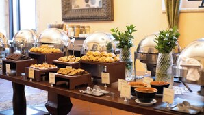 A buffet with various food items and a decorative vase.