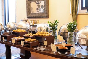 A buffet with various food items and a decorative vase.