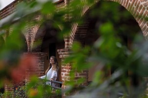 Una persona de pie frente a una estructura de ladrillo con un arco de entrada.
