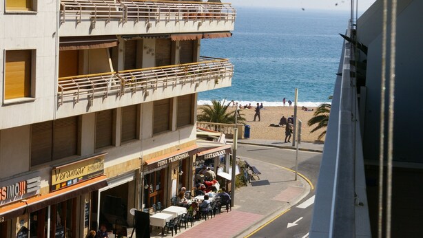 A multi-story building with balconies overlooking a beach. - Apartamento Ancora (Tossa de Mar)