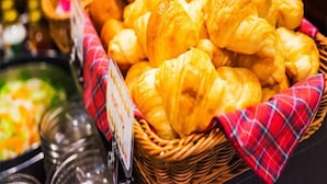 Een buffet met diverse gerechten, waaronder croissants en andere gebakken producten.
