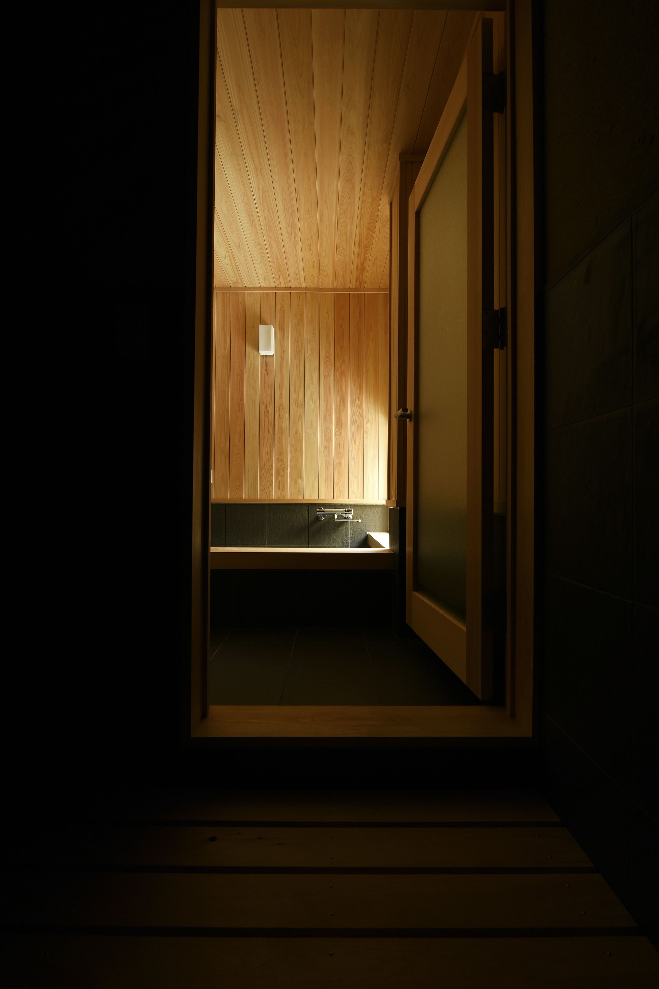 A wooden interior with a bench and a sink.