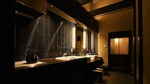 A modern bathroom with a large mirror, a sink, and a kettle on the counter. - Kuraya Omiya-Shimabara (Kyoto)