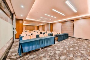 A conference room with a long table, chairs, and a carpeted floor. - Camellia Hotel (Kunming)