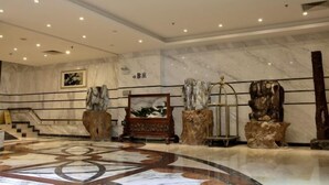 A spacious lobby with a marble floor, a staircase, and a large painting on the wall. - Camellia Hotel (Kunming)