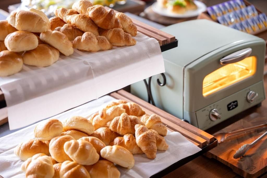 Una cocina con horno tostador antiguo y bandejas de pan recién horneado.