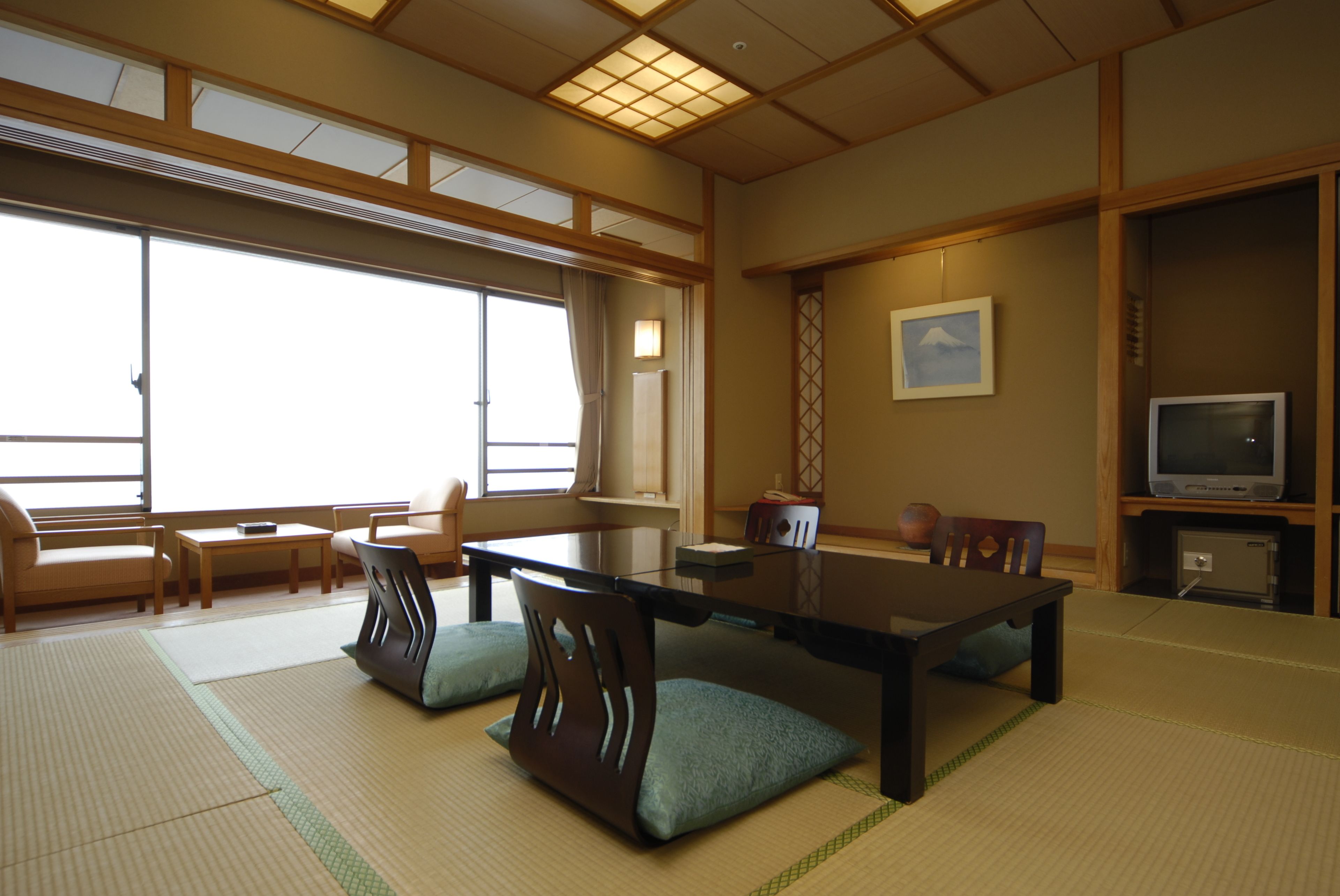 A traditional Japanese room with tatami flooring, a low table, and wooden furniture.