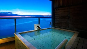 Un jacuzzi con vistas a una gran masa de agua y montañas.