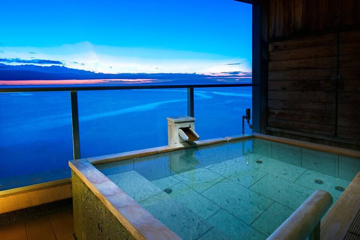 Ein Whirlpool mit Blick auf ein großes Gewässer und Berge.