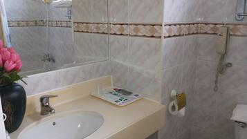 Ein Badezimmer mit Waschbecken, Spiegel, Toilette und Dusche.