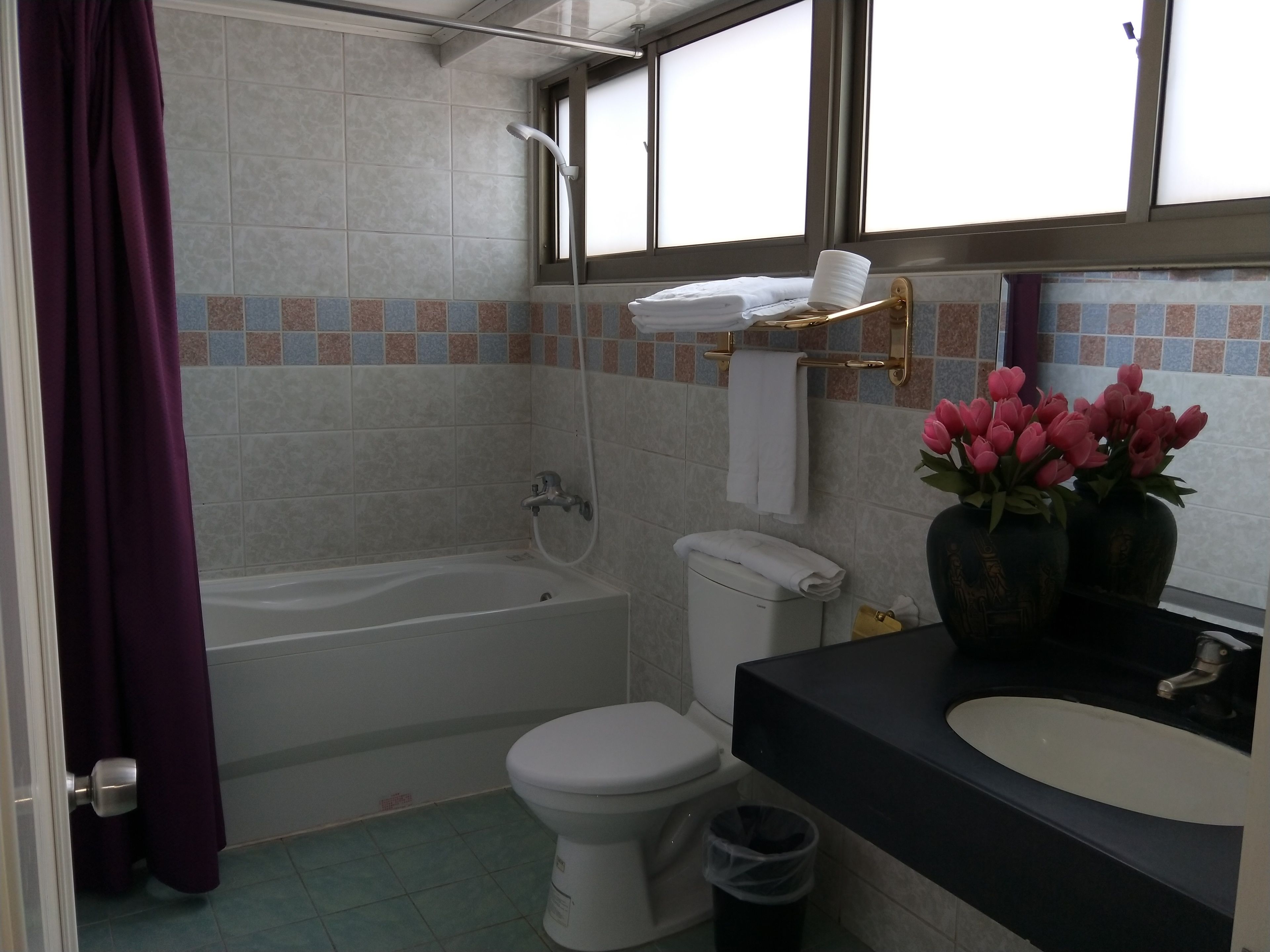 A bathroom with a bathtub, toilet, and sink.