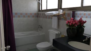 A bathroom with a bathtub, toilet, and sink.