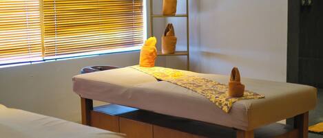 A room with a bed, a wooden cabinet, and a shelf with folded towels.