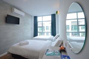 Habitación de hotel con dos camas, un televisor de pantalla plana, un espejo grande y una ventana con cortinas.