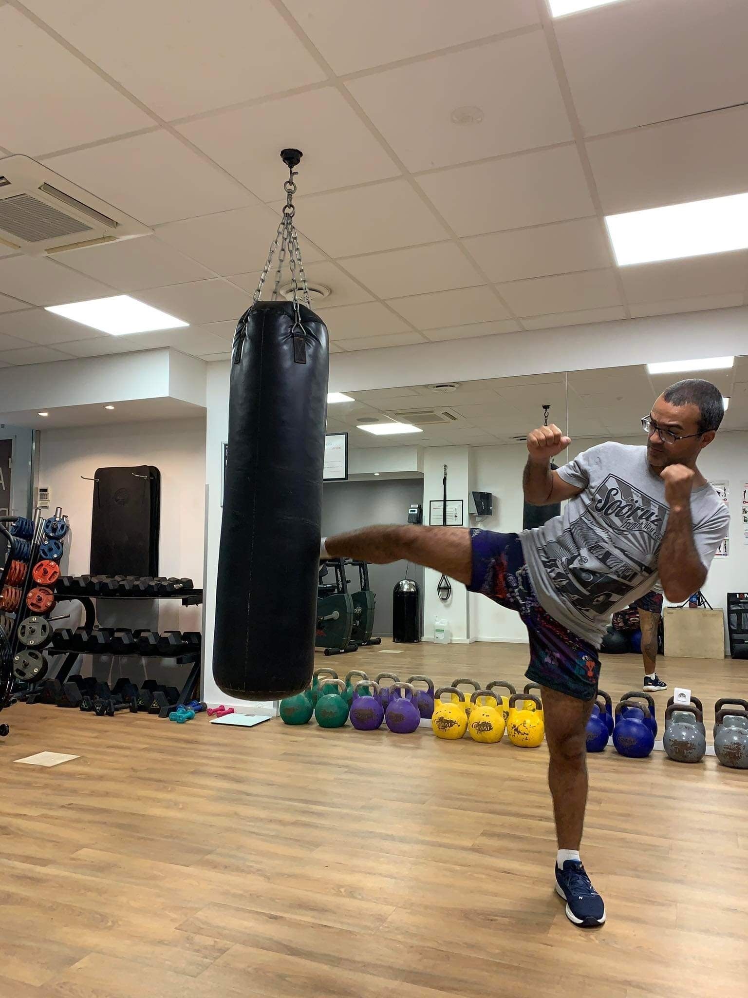 Ein Fitnessraum mit einem Sandsack, Gewichten und Trainingsbällen.