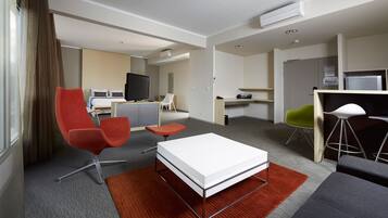 Een hotelkamer met een bed, een televisie, een bureau, een stoel en een bank.