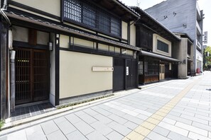 Ein traditionelles japanisches Gebäude mit einem Ziegelfassade, Holztüren und einem Schild.