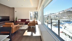 A modern living room with a large window overlooking a snowy landscape. - Mountainside Hakuba (Hakuba)