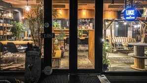 A restaurant with a 'CLOSE' sign, wooden interior, and a 'WELCOME' sign outside. - Mountainside Hakuba (Hakuba)