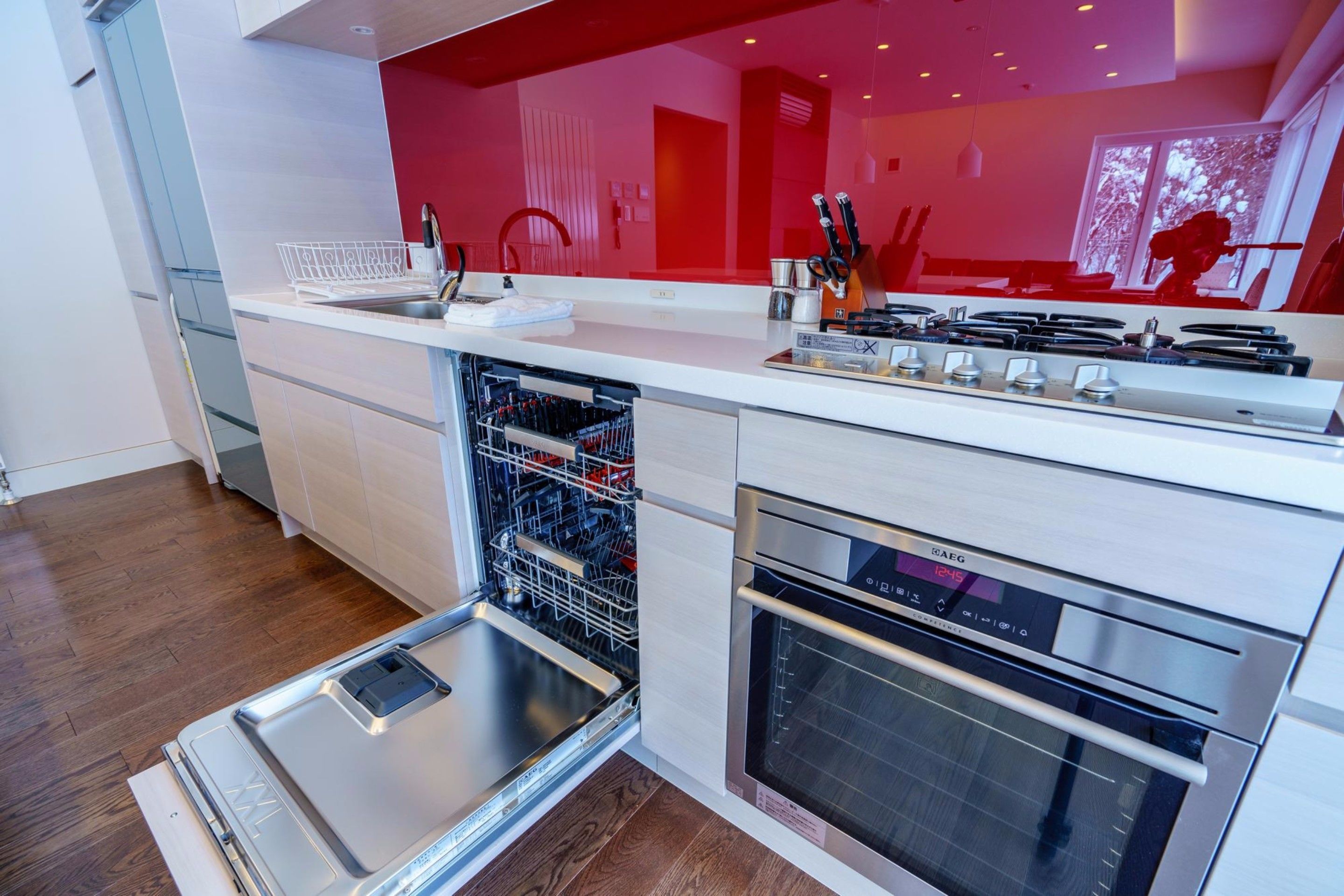 Una cocina moderna con lavavajillas, horno y encimera blanca.