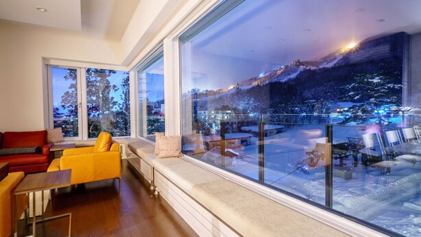 A modern living room with a large window overlooking a snowy landscape. - Mountainside Hakuba (Hakuba)