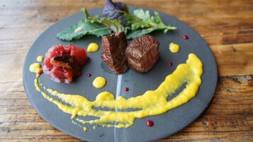 Un piatto con carne, verdure e salsa.