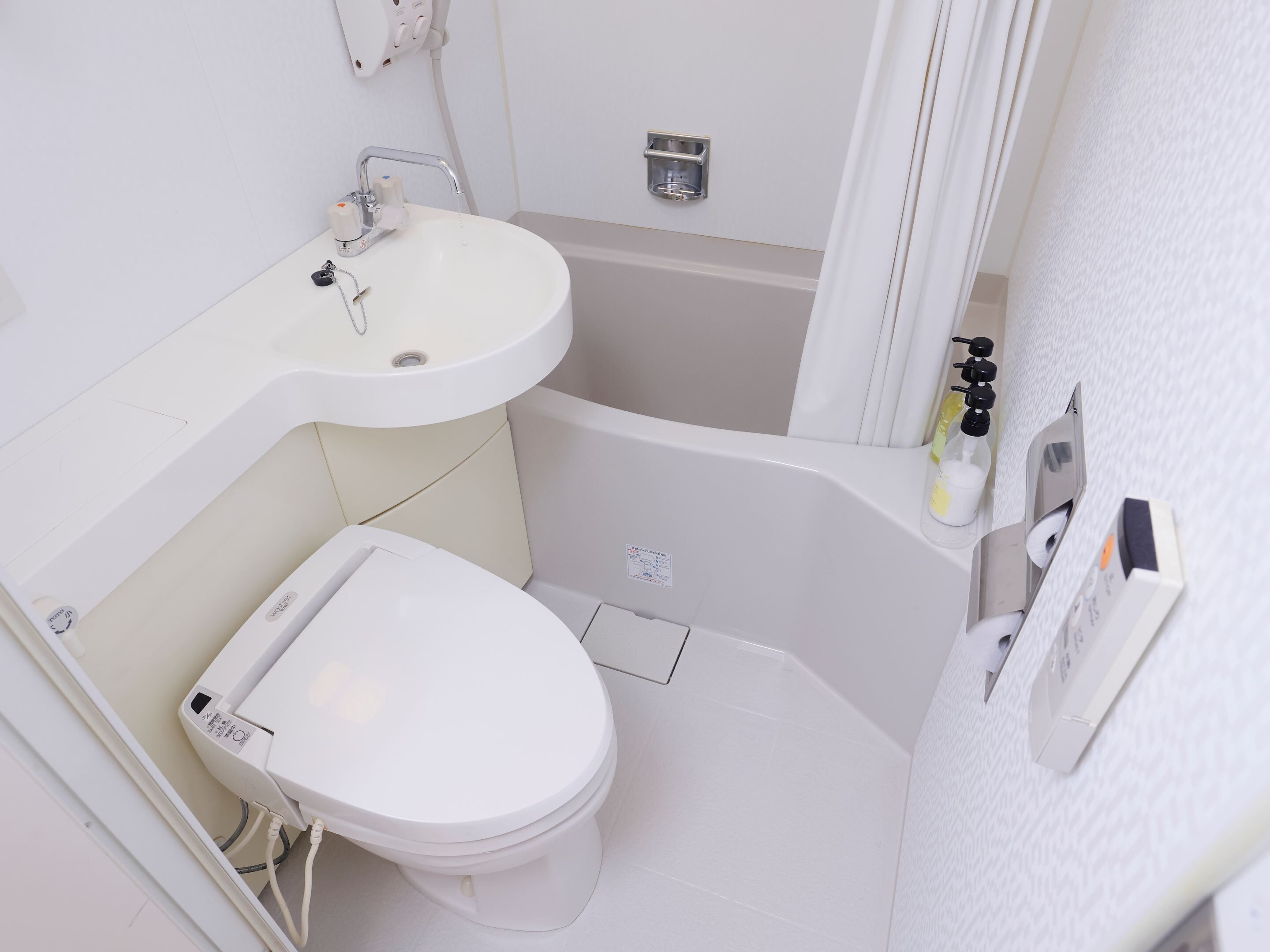 A small, white bathroom with a toilet, sink, and bathtub.