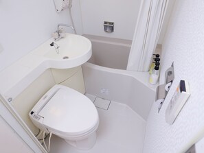 A small, white bathroom with a toilet, sink, and bathtub. - Kanko Hotel Tamaru (Nara)
