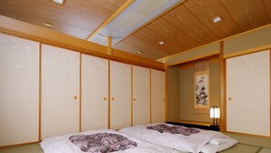Una habitación tradicional japonesa con suelo de tatami, dos camas con ropa de cama floral, puertas correderas y un cuadro en la pared.